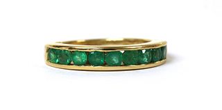 An 18ct gold emerald half eternity ring,