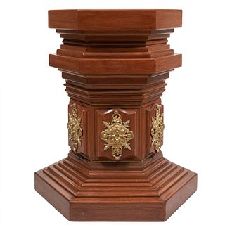 Pedestal. SXX. Elaborado en madera sólida. Con basal y capitel hexagonal. Con aplicaciones de latón dorado. 86 x 77 x 77 cm.