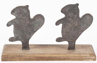 Pair of cast iron squirrel shooting gallery targets, early 20th c., on a stand, 7 1/4'' h., 12'' w.