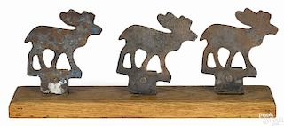 Three cast iron moose shooting gallery targets, early 20th c., on a stand, 7 1/2'' h., 18'' w.