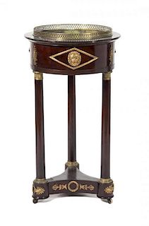 A French Empire Style Gilt Metal Mounted Mahogany Jardiniere Stand Height 35 x diameter 19 inches.