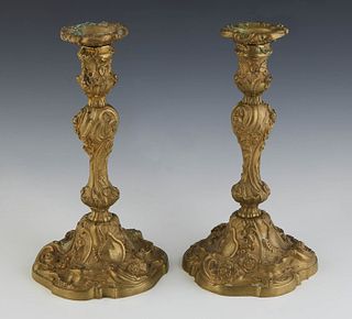 Pair of Gilt Bronze Candlesticks, c. 1900, the floriform bobeche atop a knopped support with relief floral decoration, on a like decorated scalloped b