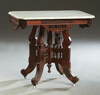 American Carved Walnut Marble Top Lamp Table, c. 1880, the ogee edge canted corner white marble top on a base with pierced spindled galleries on each 