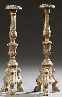 Pair of Italian Carved Giltwood Candle Sticks, 19th c., the candle cup on a tapered knopped support, to a tripodal sloping base on paw feet, H.- 17 in