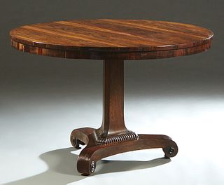 English Carved Rosewood Tilt Top Breakfast Table, 19th c., the circular top over a wide skirt, on a tapered triangular support, to a tripartite base o