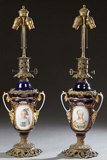 Pair of Brass and Iron Mounted Old Paris Porcelain Oil Lamps, 19th c., with an Odin regulator, the cobalt covered urn with a gilt floral reserve on on