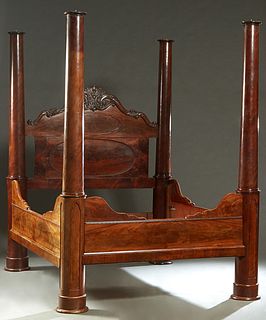 An American Rococo Carved Mahogany Four Poster Bed, mid-19th c., having faceted tapered cylindrical posts of Gothic inspiration, the arched scalloped 