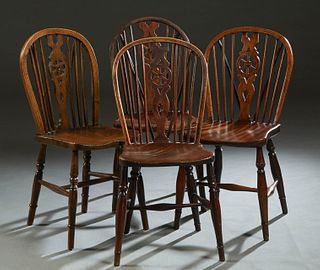 Set of Four English Carved Elm Wheelback Windsor Side Chairs, early 20th c., the curved canted back with vertical spindles and a central pierced wheel