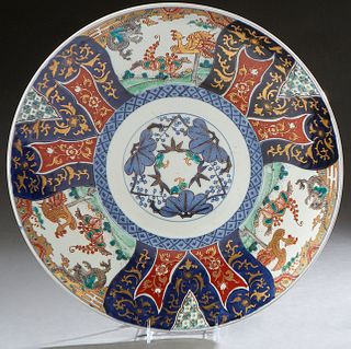 Large Japanese Imari Porcelain Circular Charger, 20th c., the edge around medallion reserves of flowers, dragons, and birds, around a central circular
