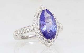 Lady's 18K White Gold Dinner Ring, with a 3.42 carat marquise tanzanite, atop a border of round diamonds, the shoulders of the band also mounted with 