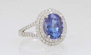 Lady's Platinum Dinner Ring, with an oval 2.76 carat tanzanite atop a double concentric graduated border of round diamonds, the split shoulders of the