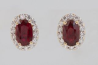 Pair of 18K Yellow Gold Stud Earrings, each with an oval ruby atop a border of tiny round diamonds, with screw posts, total ruby wt.- 2.15 cts, total 
