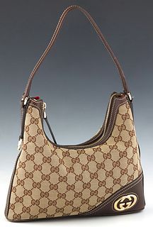 Gucci Mini Britt Hobo Bag, in beige monogram canvas with dark brown leather accents and gold hardware, opening to a red striped canvas lined interior 