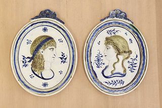 A pair of oval moulded pottery plaques,