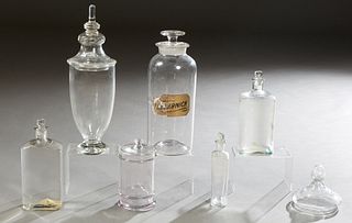 Group of Six Glass Apothecary Items, early 20th c., consisting of a large circular stoppered drug jar, with a partial glass label for "Flo. Arnica," t