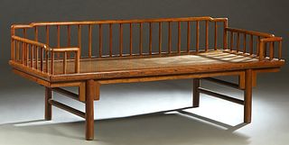 Chinese Carved Elm Daybed, 20th c., with three arched spindled rail sides, over a rattan seat, on cylindrical legs joined by cylindrical stretchers, H