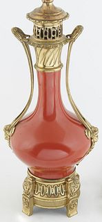 Chinese Oxblood Gilt Bronze Mounted Baluster Vase, 20th c., with pierced figural handles, on a stepped circular base, now wired as a lamp, H.- 17 in.,