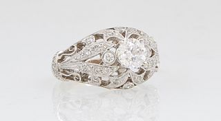 Lady's 18K White Gold Dinner Ring, with a central round .71 carat diamond, flanked by two small round diamonds and a pierced diamond mounted top and s