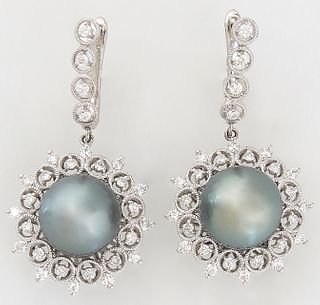 Pair of Platinum Pendant Earrings, with a diamond mounted half hoop suspending a 12mm dark gray Tahitian cultured pearl, atop a pierced frame of diamo