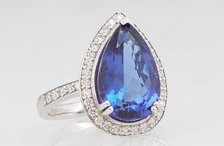 Lady's Platinum Dinner Ring, with a pear shaped 7.84 carat tanzanite, atop a conforming border of small round white diamonds, the shoulders of the ban