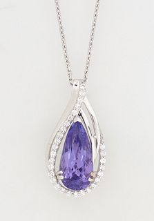 Lady's 18K White Gold Pendant, with a 3.65 carat pear shaped tanzanite, the pierced border mounted with round diamonds on two sides, beneath a diamond