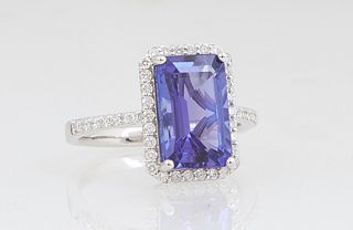 Lady's 14K White Gold Dinner Ring, with a 4.16 carat emerald cut tanzanite, atop a border of tiny round diamonds, the shoulders of the band also mount