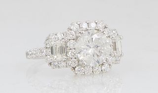 Lady's 18K White Gold Dinner Ring, with a central 2.03 carat round diamond, atop an octagonal border of round diamonds, flanked by diamond bordered lu