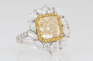 Lady's 18K White Gold Dinner Ring, with a 2 carat fancy yellow rectangular cut diamond, within a border of thirty tiny round yellow diamonds, atop a b
