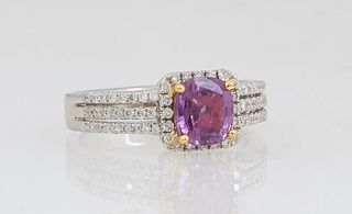 Lady's 18K White Gold Dinner Ring, with an oval 1.66 carat cushion cut pink sapphire, atop a conforming border of tiny round diamonds, the triple spli