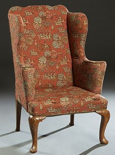 English Queen Anne Style Carved Mahogany Wing Chair, 20th c., the serpentine back over two wings, to curved scrolled upholstered arms and a cushion se