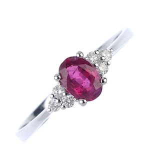 An 18ct gold ruby and diamond dress ring. The oval-shape ruby, with brilliant-cut diamond trefoil si