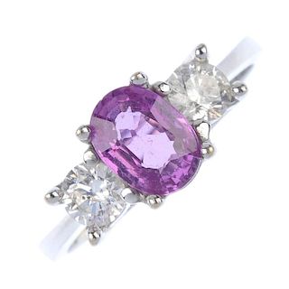 An 18ct gold sapphire and diamond three-stone ring. The oval-shape pink sapphire, to the brilliant-c
