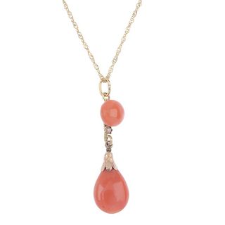 A coral and split pearl pendant. The coral drop with textured cap, suspended from a split pearl and