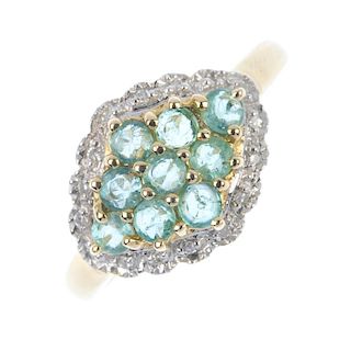 A 9ct gold emerald and diamond cluster ring. The circular-shape emerald lozenge-shape cluster, withi