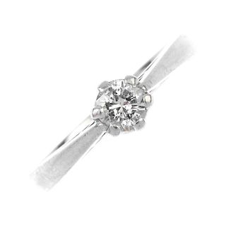 A platinum diamond single-stone ring. The brilliant-cut diamond, to the tapered shoulders and plain