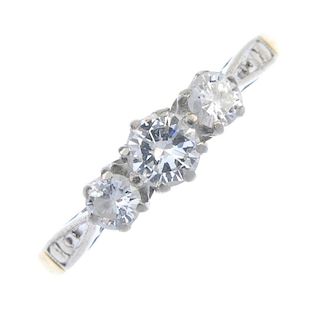 A diamond three-stone ring. The brilliant-cut diamond, with similarly-cut diamond sides, to the plai