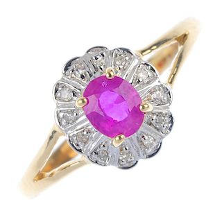 A 9ct gold ruby and diamond cluster ring. The oval-shape ruby, within a single-cut diamond surround,