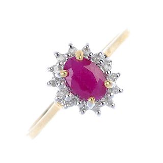 A 9ct gold ruby and diamond cluster ring. The oval-shape ruby, within a single-cut diamond surround,