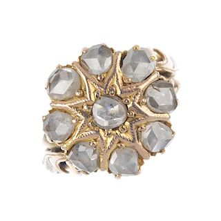 An 18ct gold diamond cluster ring. The rose-cut diamond star, within a similarly-cut diamond surroun