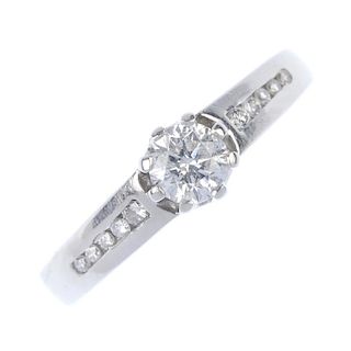 An 18ct gold diamond single-stone ring. The brilliant-cut diamond, with similarly-cut diamond line s