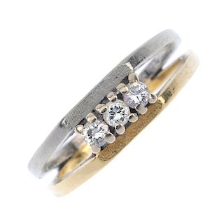 An 18ct gold diamond three-stone ring. Of bi-colour design, the brilliant-cut diamond line, within t