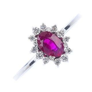 An 18ct gold ruby and diamond cluster ring. The oval-shape ruby, within a brilliant-cut diamond undu