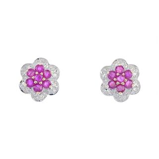 A pair of ruby and diamond cluster ear studs. Each designed as a circular-shape ruby cluster, within