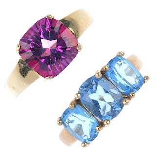 A selection of four 9ct gold gem-set rings. To include a blue topaz three-stone ring, a garnet singl
