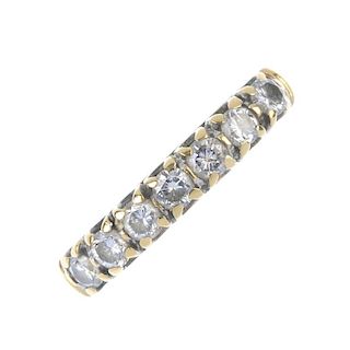 An 18ct gold diamond seven-stone ring. The brilliant-cut diamond line, to the tapered band. Total di