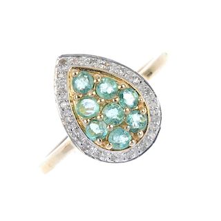 A 9ct gold emerald and diamond cluster ring. The circular-shape emerald pear-shape cluster, within a