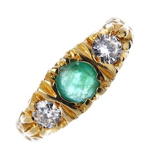 An 18ct gold emerald and diamond ring. The circular-shape emerald, with brilliant-cut diamond sides,