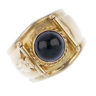 An onyx dress ring. The circular onyx cabochon, within a rope-twist surround, to the plain bar sides