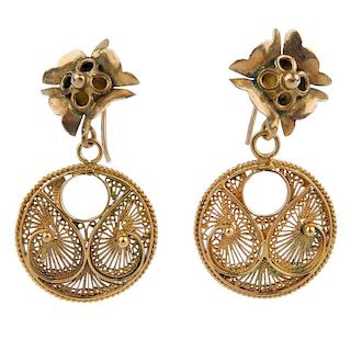 A pair of filigree ear pendants. Each designed as a scrolling filigree disc, suspended from a kite-s