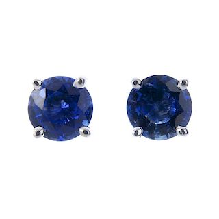 * A pair of sapphire single-stone ear studs. Each designed as a circular-shape sapphire, within a cl